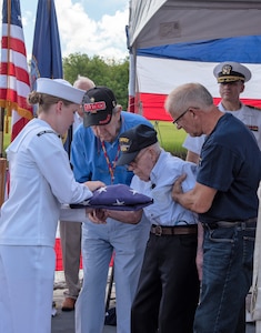 U.S. Navy Seaman Jacey Pruitt, left, a hospital corpsman serving at Naval Health Clinic Charleston, presents the American flag to WWII Veteran Waitman Kapaldo during a memorial service July 6, 2018, aboard the USS Laffey in Mount Pleasant, S.C.