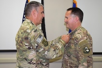 Col. James Phillips, former 919th Special Operations Wing commander, pins the Legion of Merit medal on Col. Brian Stahl following his retirement from the Air Force July, 15, 2018.