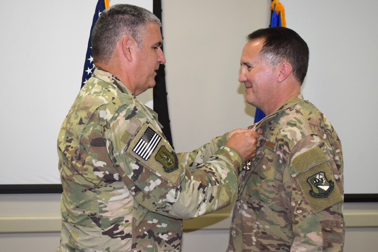 Col. James Phillips, former 919th Special Operations Wing commander, pins the Legion of Merit medal on Col. Brian Stahl following his retirement from the Air Force July, 15, 2018.
