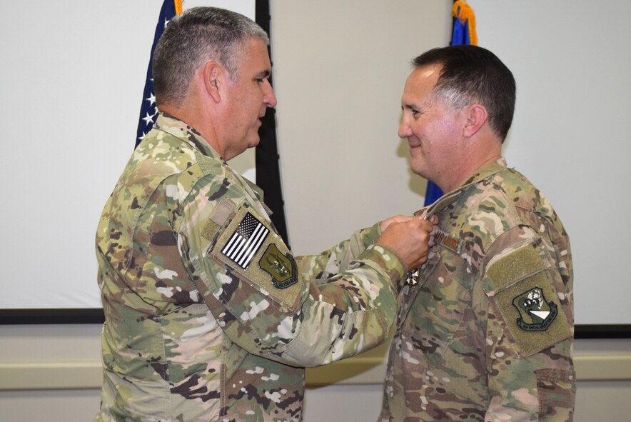 Col. James Phillips, former 919th Special Operations Wing commander, pins the Legion of Merit medal on Col. Brian Stahl following his retirement from the Air Force July, 15, 2018.