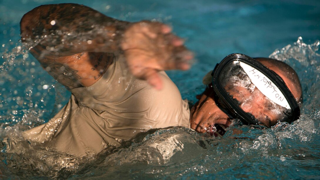 An Airman swims while wearing goggles.