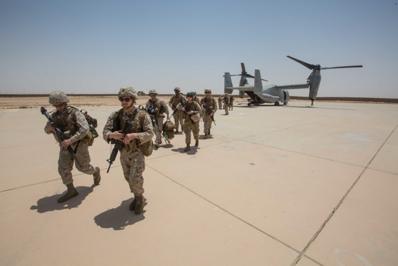 Marines walk from an MV-22B Osprey