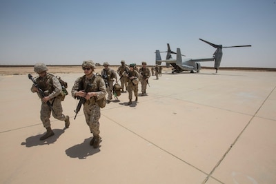 Marines walk from an MV-22B Osprey