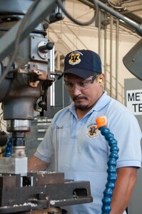 Carlos Casasola, 12th Maintenance Group metals technology shop, machinist, forms a flat surface on a block of metal using a vertical milling machine, July 2, 2018, at Joint Base San Antonio-Randolph, Texas. The maintenance group executes more than 40,000 flight hours annually supporting six training operations squadrons.