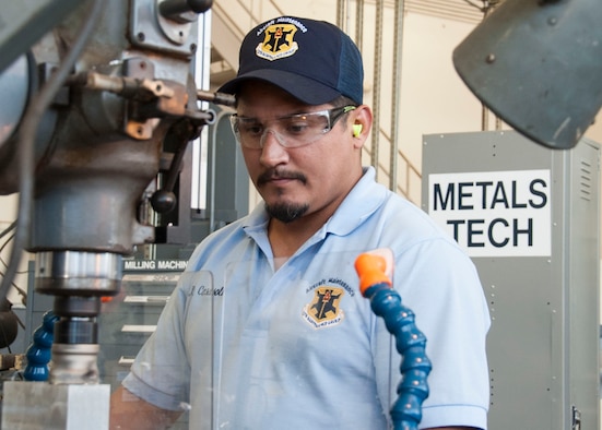 Carlos Casasola, 12th Maintenance Group metals technology shop, machinist, forms a flat surface on a block of metal using a vertical milling machine, July 2, 2018, at Joint Base San Antonio-Randolph, Texas. The maintenance group executes more than 40,000 flight hours annually supporting six training operations squadrons. (U.S. Air Force photo by Tech. Sgt. Ave I. Young)