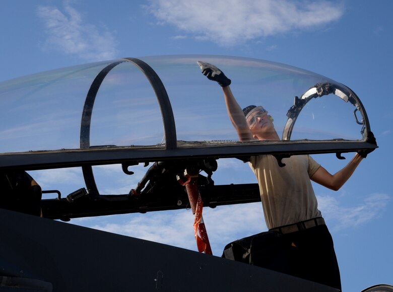 Airman 1st Class Lucas Cupp, F-15E Strike Eagle fighter jet assistant dedicated crew chief assigned to 757th Maintenance Squadron Strike Aircraft Maintenance Unit, cleans the canopy of an F-15E Strike Eagle at Nellis Air Force Base, Nevada. Dedicated crew chiefs and ADCCs are expected to be exceptional maintainers, take pride in their work and assume a large amount of responsibility. (U.S. Air Force photo by Airman Bailee A. Darbasie)