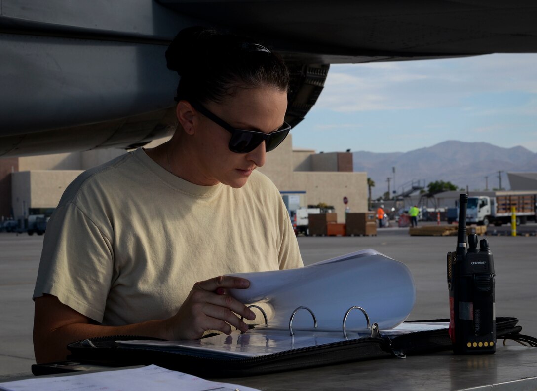 Master Sgt. Sarah Flagg, production superintendent assigned to 757th Maintenance Squadron Strike Aircraft Maintenance Unit, reviews aircraft forms in preparation of an F-15E Strike Eagle fighter jet take off at Nellis Air Force Base, Nevada. Attention to detail is important for everyone working on the flightline to ensure the safety of maintainers and aircrew. (U.S. Air Force photo by Airman Bailee A. Darbasie)