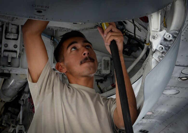Airman 1st Class Bonifacio Garcia, F-15E Strike Eagle fighter jet assistant dedicated crew chief assigned to 757th Maintenance Squadron Strike Aircraft Maintenance Unit, disconnects a hose from an F-15E Strike Eagle at Nellis Air Force Base, Nevada. ADCCs are responsible for supporting dedicated crew chiefs with all work pertaining to their aircraft. (U.S. Air Force photo by Airman Bailee A. Darbasie)