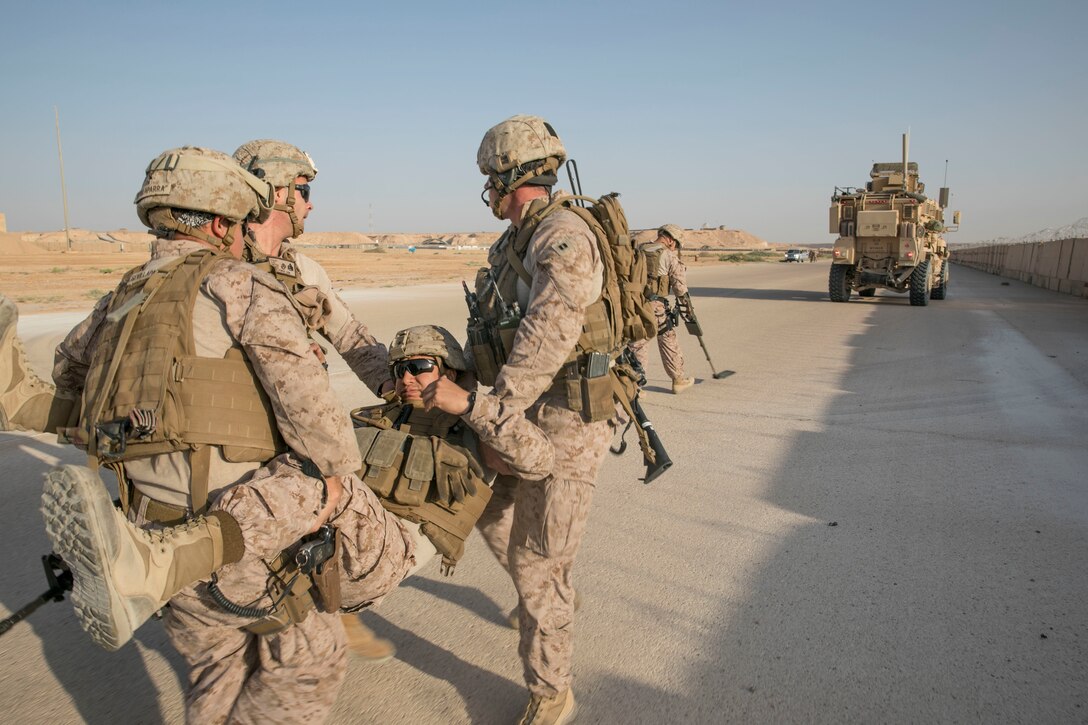 A group of Marines, from Task Force Lion, conduct casualty care training after being hit by a simulated improvised explosive device during a training exercise on Al Asad Airbase, Iraq, July 5, 2018. There are 75 Coalition partners committed to the goal of eliminating the threat posed by ISIS in Iraq and Syria and have contributed in various capacities to the effort. (U.S. Army photo by Sgt. Zakia Gray)