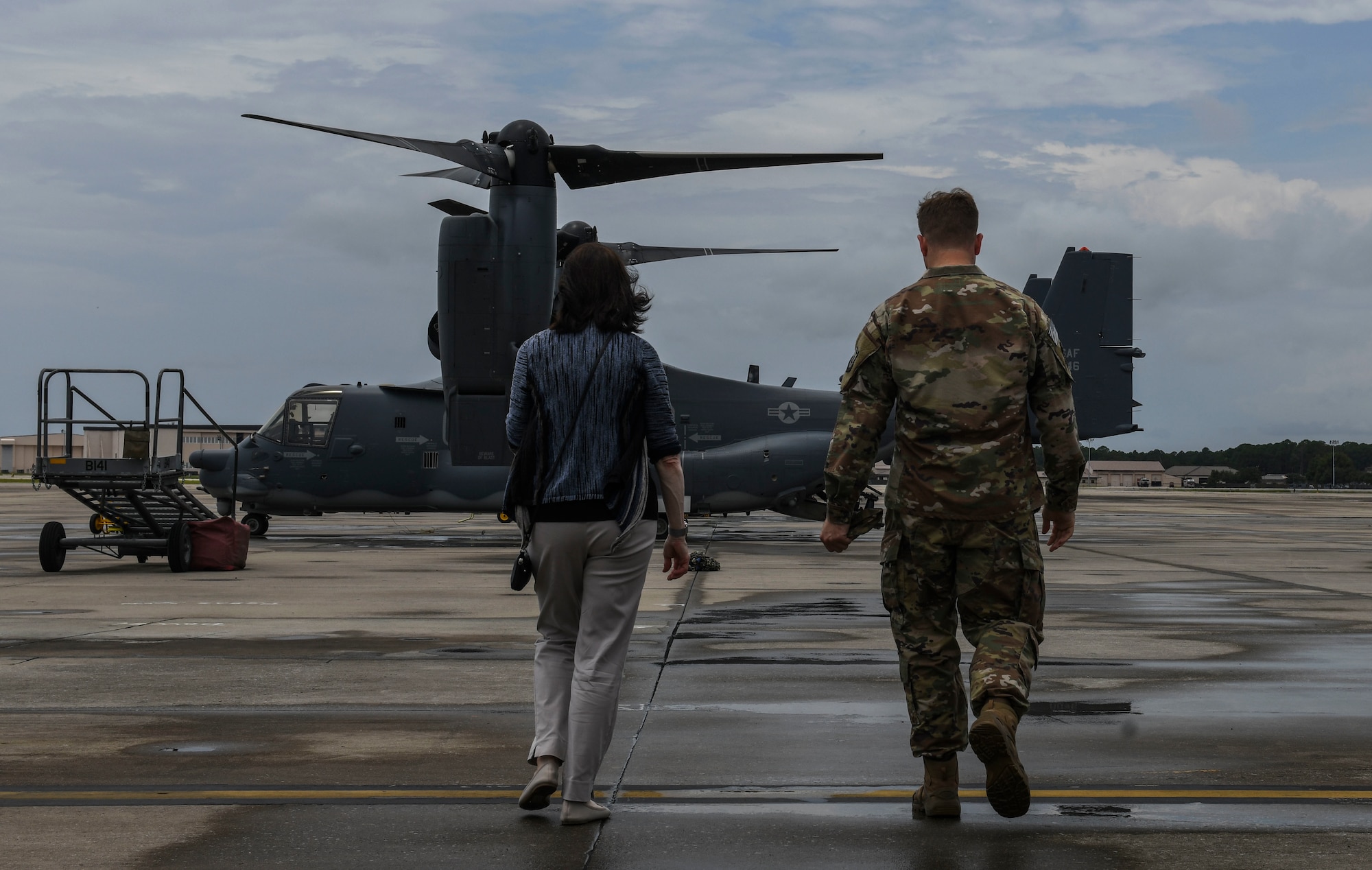 Two people walking toward an aircraft.