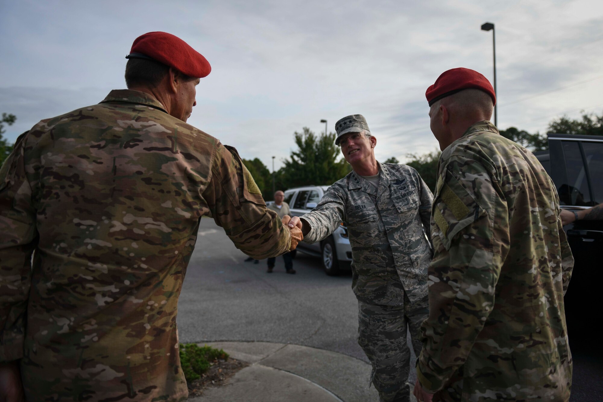 Three people greeting one another; shaking hands