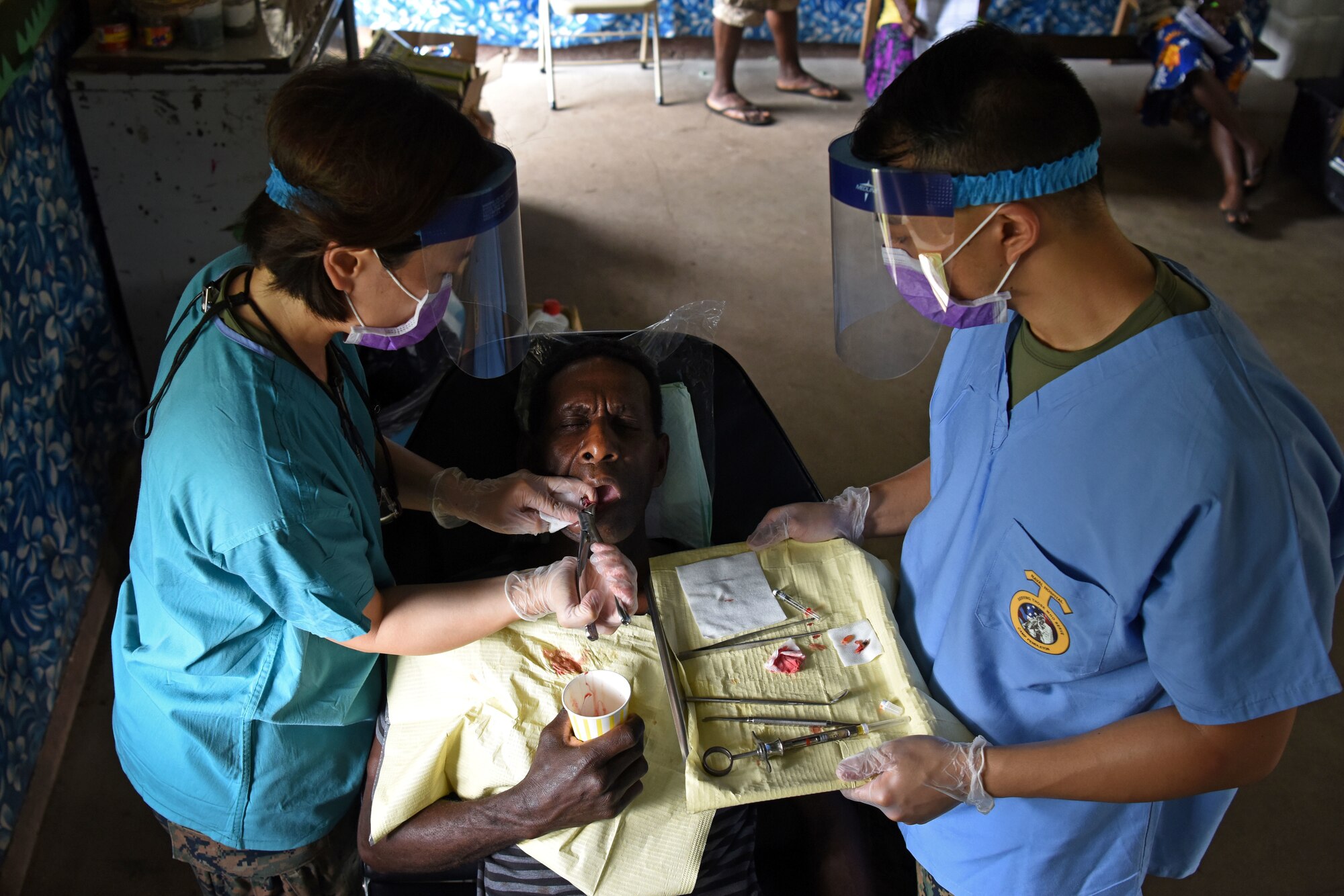 (left) U.S. Navy Lt. Denise Chiu, dentist, and Hospital Corpsman 3rd Class Allan Callanta, dental technician, with the 1st Dental Battalion, Camp Pendleton, Calif., extract a patient’s tooth at Tata Primary and Secondary School during Pacific Angel 18-3 in Luganville, Espiritu Santo Island, Vanuatu, July 16, 2018.