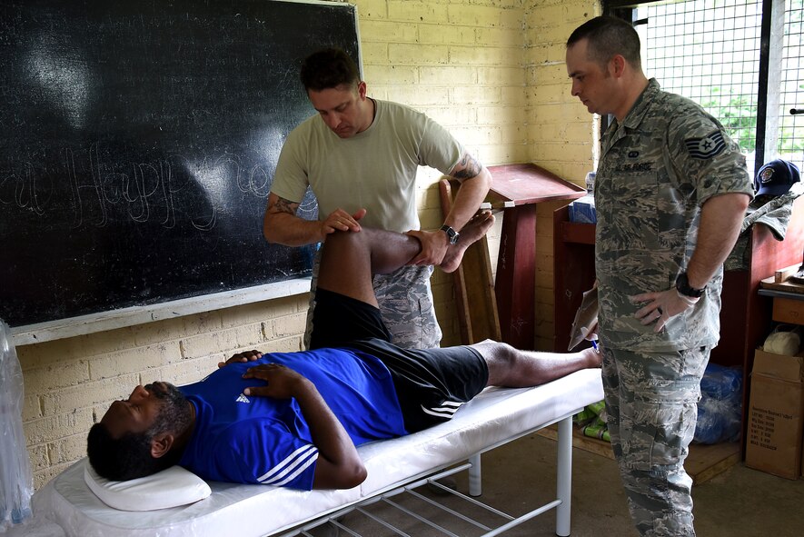 U.S. Air Force Maj. Brian Smith, a physical therapist with the 35th Medical Group, Misawa Air Base, Japan, center, and Tech. Sgt. Manuel Carrillo, a physical therapy technician with the 354th Medical Group, Eielson Air Force Base, Alaska, check a patient’s range of motion at Tata Primary and Secondary School during Pacific Angel 18-3 in Luganville, Espiritu Santo Island, Vanuatu, July 16, 2018.