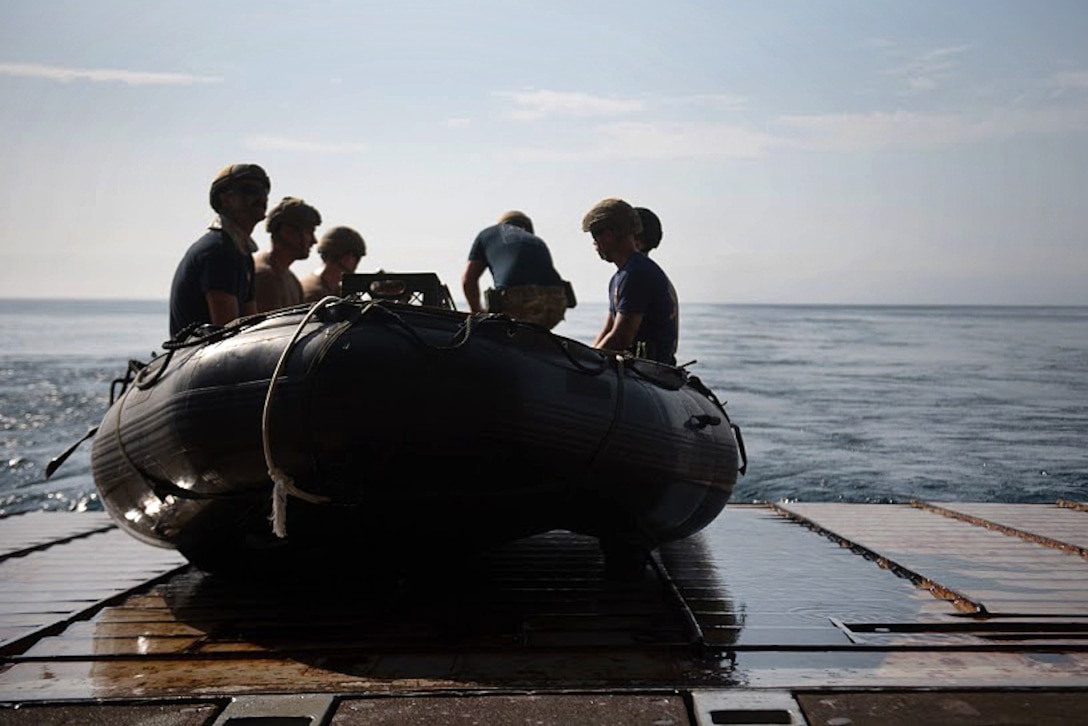 Sailors prepare to launch a combat rubber raiding craft.