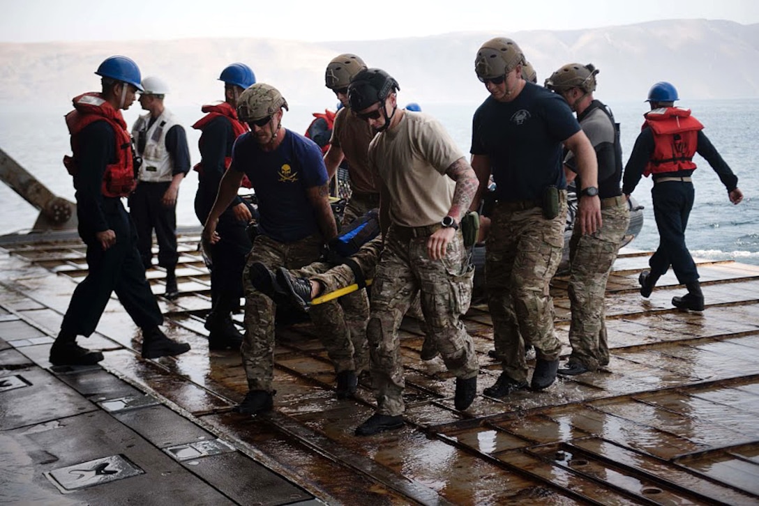Sailors carry a mock casualty in a stretcher during a man-down drill.