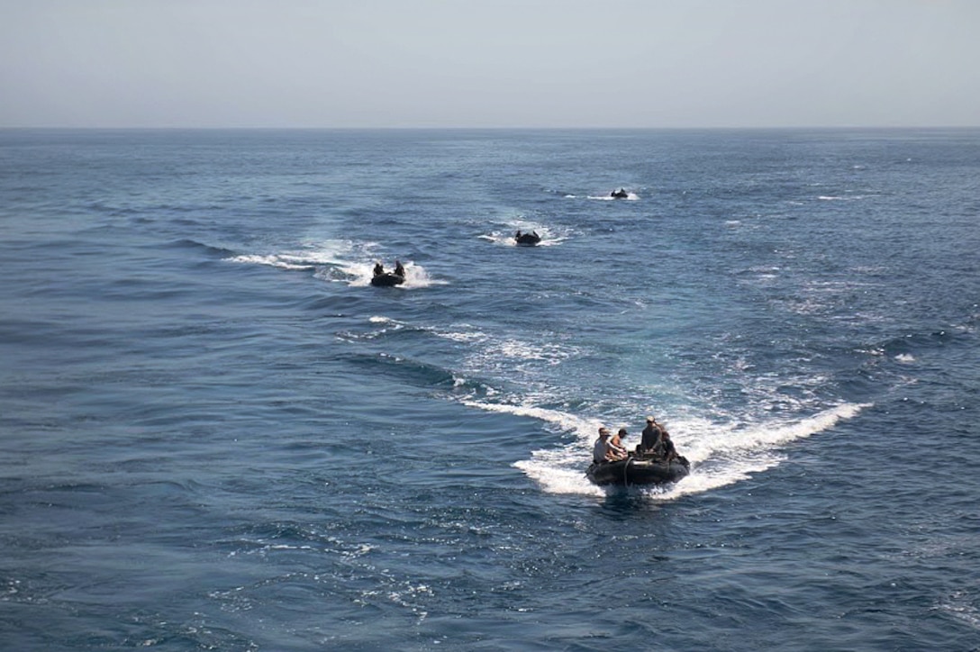 Sailors maneuver their combat rubber raiding crafts.