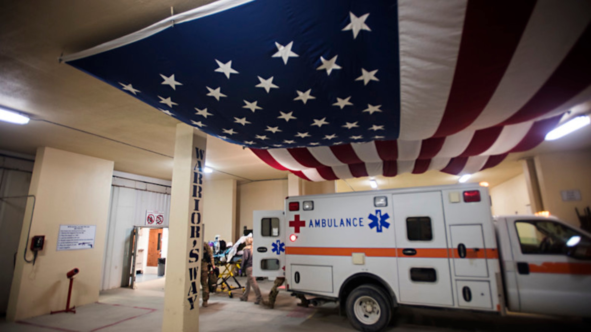 Members of the 455th Expeditionary Aeromedical Evacuation Squadron carry a patient from an ambulance into the Craig Joint Theater Hospital at Bagram Airfield, Afghanistan