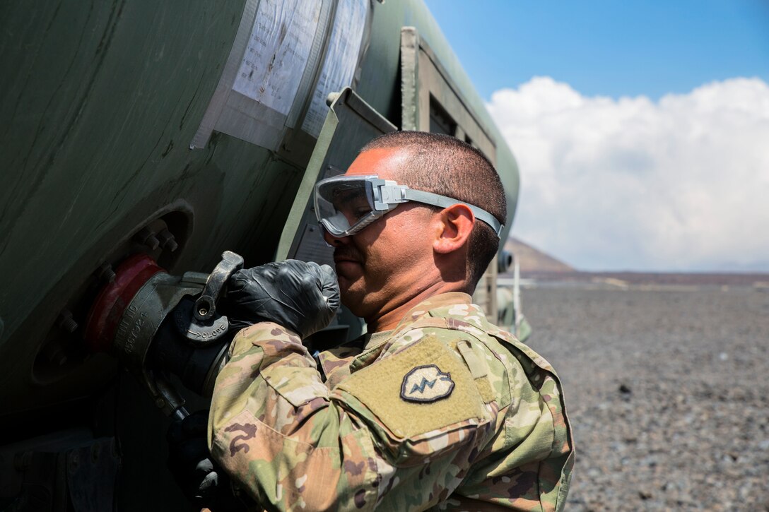 U.S. Army Pfc. Ronald Campbell, a petroleum laboratory specialist this the 25th Sustainment Brigade, 25th Infantry Division, attaches a hose to a U.S. Marine Corps M-970 Semi-Trailer Refueler during a field test for an Expeditionary Mobile Fuel Additization Capability system as part of Rim of the Pacific (RIMPAC) exercise at Pohakuloa Training Area, Hawaii, July 18, 2018. RIMPAC provides high-value training for task-organized, highly capable Marine Air-Ground Task Force and enhances the critical crisis response capability of U.S. Marines in the Pacific.