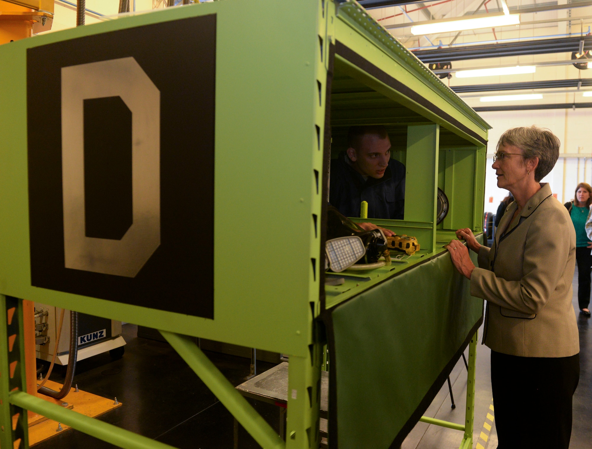 U.S. Air Force Senior Airman Patrick Leach, 100th Maintenance Squadron aircraft fuels system journeyman and Secretary of the Air Force Heather Wilson discuss the confined space trainer, a new innovation developed by the squadron at RAF Mildenhall, England, July 12, 2018. Secretary Wilson visited RAF Mildenhall to engage with Airmen from the 100th ARW and discuss innovations and strategy. (U.S. Air Force photo by Airman 1st Class Alexandria Lee)
