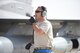 An Airman uses a head set to speaks in front of an F-16 fighter jet
