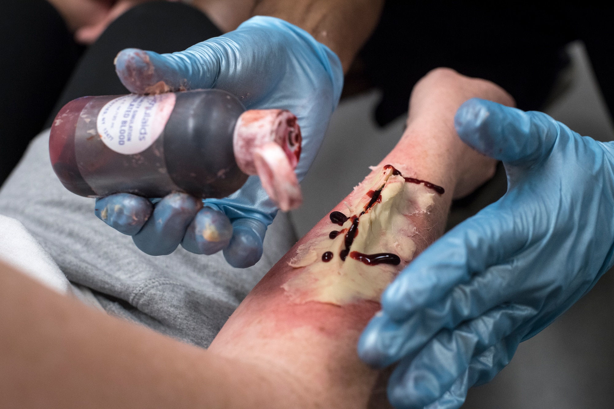 Airmen from the 23d Medical Group (MDG) create a fake wound on a simulated casualty during a mass casualty exercise, July 19, 2018, at Moody Air Force Base, Ga. The exercise tested the MDG’s emergency response capabilities during a chemical attack. (U.S. Air Force photo by Senior Airman Janiqua P. Robinson)
