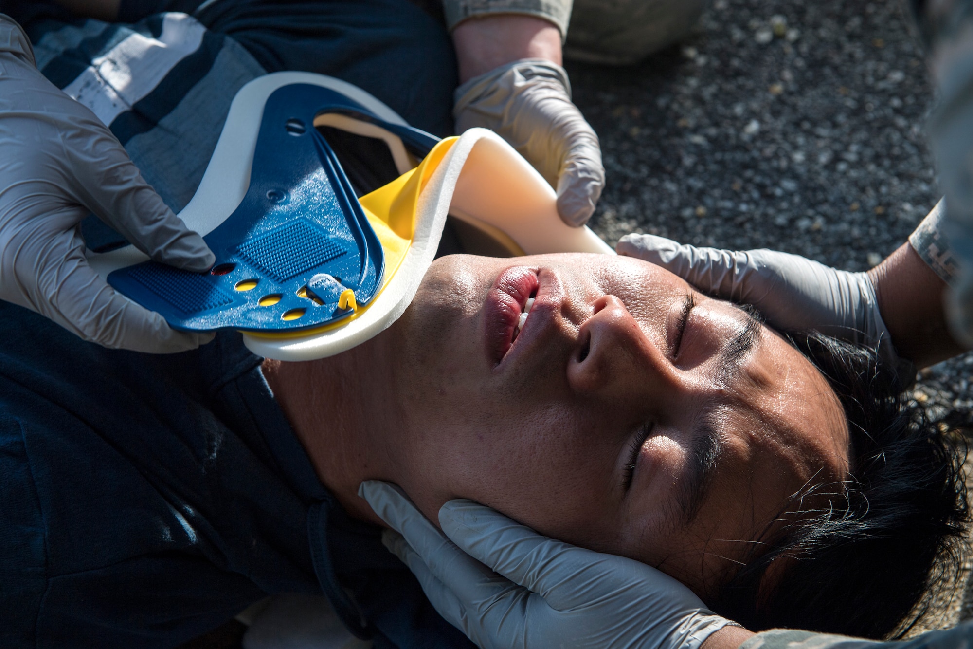Airmen from the 23d Medical Group put a cervical collar on a simulated victim during a mass casualty exercise July 19, 2018, at Moody Air Force Base, Ga. The exercise tested the MDG’s emergency response capabilities during a chemical attack. (U.S. Air Force photo by Senior Airman Janiqua P. Robinson)