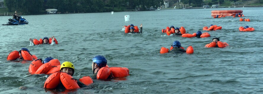 170th Group members, assigned to Offutt Air Force Base, Nebraska, swim toward a raft while participating in water survival and rescue training July 14, 2018. The aircrew members were briefed on the availability and use of tools contained in their survival gear before putting academics and theory to the test in the waters of a local lake.