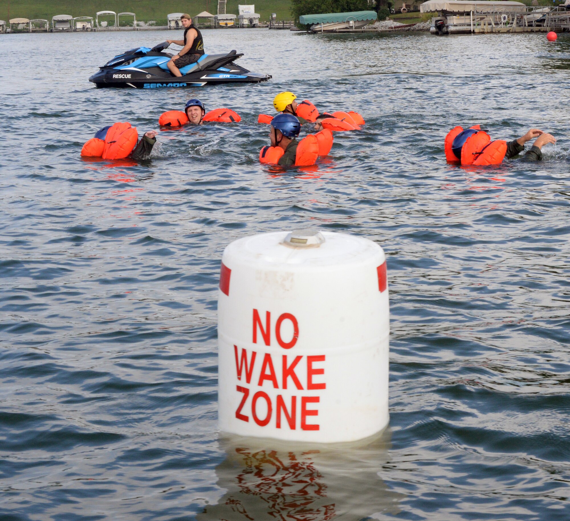 Citizen Airmen, assigned to the 170th Group at Offutt Air Force Base, Nebraska, swim toward a raft under the watchful eye of Staff Sgt. Kevin Battista, 55th Operational Support Squadron Survival Evasion Resistance Escape specialist, while participating in water survival and rescue training July 14, 2018 during monthly inactive duty training. The hands-on water instruction included donning cold-water exposure suits; inflating and swimming with inflatable life preservers; and boarding and utilizing a 20-person survival raft.