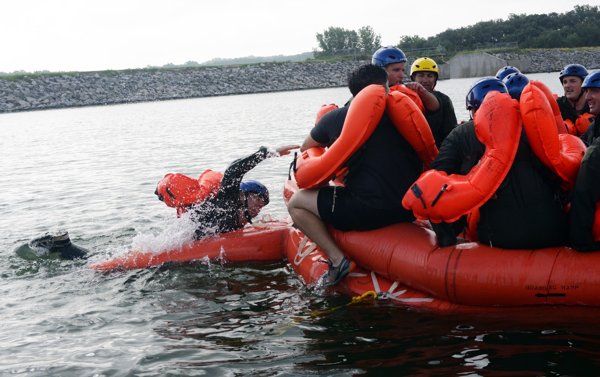 A 170th Group Citizen Airman, assigned to Offutt Air Force Base, Nebraska, hoists himseld out of the water and onto a raft while participating in water survival and rescue training July 14, 2018. The aircrew members were briefed on the availability and use of tools contained in their survival gear before putting academics and theory to the test in the waters of a local lake.