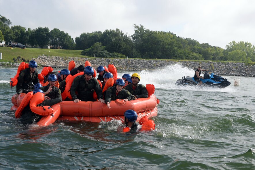 170th Group Citizen Airmen, assigned to Offutt Air Force Base, Nebraska, prepare their raft for rough seas, simulated by Staff Sgt. Kevin Battista, 55th Operational Support Squadron Survival Evasion Resistance Escape specialist, while participating in water survival and rescue training July 14, 2018. The aircrew members were briefed on the availability and use of tools contained in their survival gear before putting academics and theory to the test in the waters of a local lake.