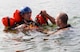 Maj. Kevin Selin, member of the 170th Group assigned to Offutt Air Force Base, Nebraska, is instructed in the use of an extraction tool by Staff Sgt. Neal Troyer, 55th Operational Support Squadron Squadron Survival Evasion Resistance Escape specialist, while participating in water survival and rescue training July 14, 2018. The hands-on water instruction included donning cold-water exposure suits; inflating and swimming with inflatable life preservers; and boarding and utilizing a 20-person survival raft.