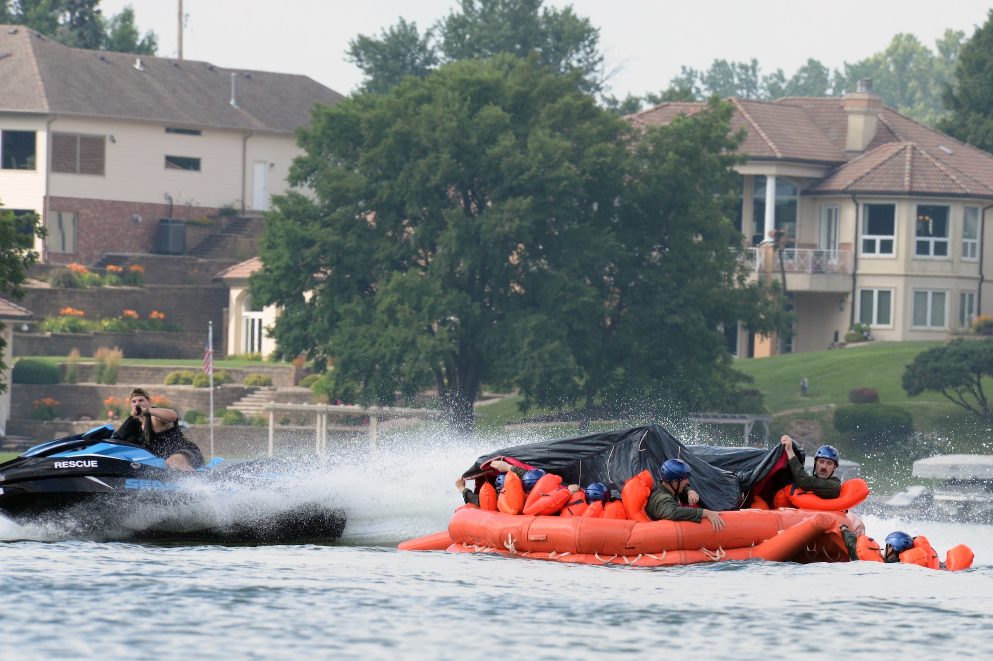 170th Group Citizen Airmen, assigned to Offutt Air Force Base, Nebraska, prepare their raft for rough seas, simulated by Staff Sgt. Kevin Battista, 55th Operational Support Squadron Survival Evasion Resistance Escape specialist, while participating in water survival and rescue training July 14, 2018. The aircrew members were briefed on the availability and use of tools contained in their survival gear before putting academics and theory to the test in the waters of a local lake.