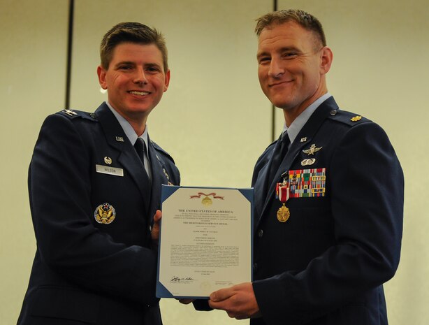 Maj. Joshua Aultman, right, 628th Communications Squadron outgoing commander, is awarded the Meritorious Service Medal by Col. Rockie Wilson, left, 628th Mission Support Group commander, during a change of command ceremony at the Charleston Club, July 29, 2018.