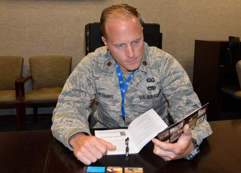 Maj. Casey Robbins, executive officer to the 1st Air Force (Air Forces Northern) vice commander, looks over one of the course cards July 12 during the “Four Lenses 4-Temperament Discovery” course. The course is a personality assessment tool that helps participants enhance both their own self-awareness and their interpersonal communication skills. (Air Force photo by Mary McHale)