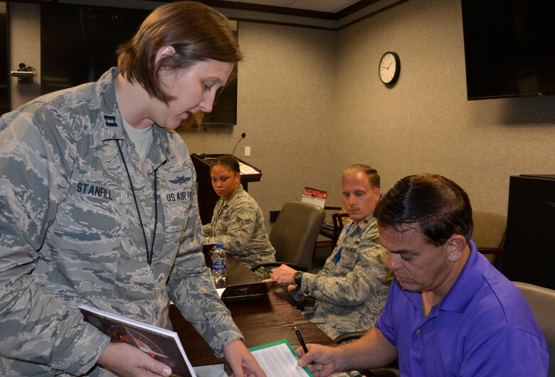 Capt. Sherri Stanfill, Deputy, Flight Chief Program and Plans, 101st Air Communications Squadron, and “Four Lenses 4-Terperament Discovery” course facilitator, assists Dan Philips, 1st Air Force (Air Forces Northern) Communications Directorate, with a question July 12. The course is a personality assessment tool that helps participants enhance both their own self-awareness and their interpersonal communication skills. (Air Force photo by Mary McHale)