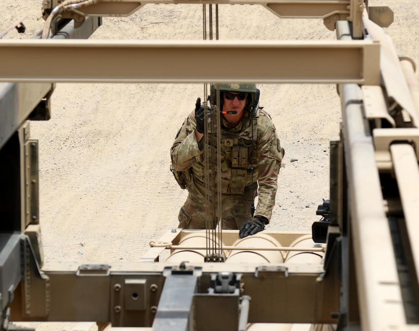 Staff Sgt. Brian Lang, a High Mobility Artillery Rocket System crew chief for Bravo Battery, 1st Battalion, 14th Field Artillery Regiment, 65th Field Artillery Brigade, Task Force Spartan, coordinates with one his Soldiers to raise the pod to load the simulated rounds for the HIMARS on June 29, 2018.  Lang, a six-year field artilleryman, is also the ammunition section chief for Bravo Battery.