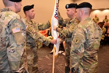 Lt. Col. Matthew Mapes, 6th Medical Recruiting Battalion outgoing commander, relinquishes the battalion colors to Col. Edward Mandril, Medical Recruiting Brigade commander and presiding officer during the 6th MRBn Change of Command Ceremony on July 19.