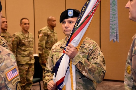 Lt. Col. Kenneth Lutz, 6th Medical Recruiting Battalion incoming commander, holds the battalion colors momentarily during the 6th MRBn Change of Command Ceremony on July 19.