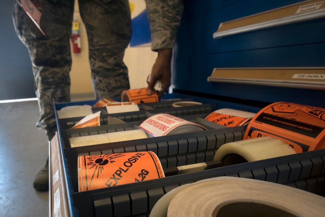 An Airman from the 23d Maintenance Squadron (MXS) grabs a roll of tape during a munitions inspection, July 10, 2018, at Moody Air Force Base, Ga. Munitions inspectors enhance Moody’s combat capabilities by inspecting and approving safe and serviceable ammo. (U.S. Air Force photo by Airman 1st Class Eugene Oliver)