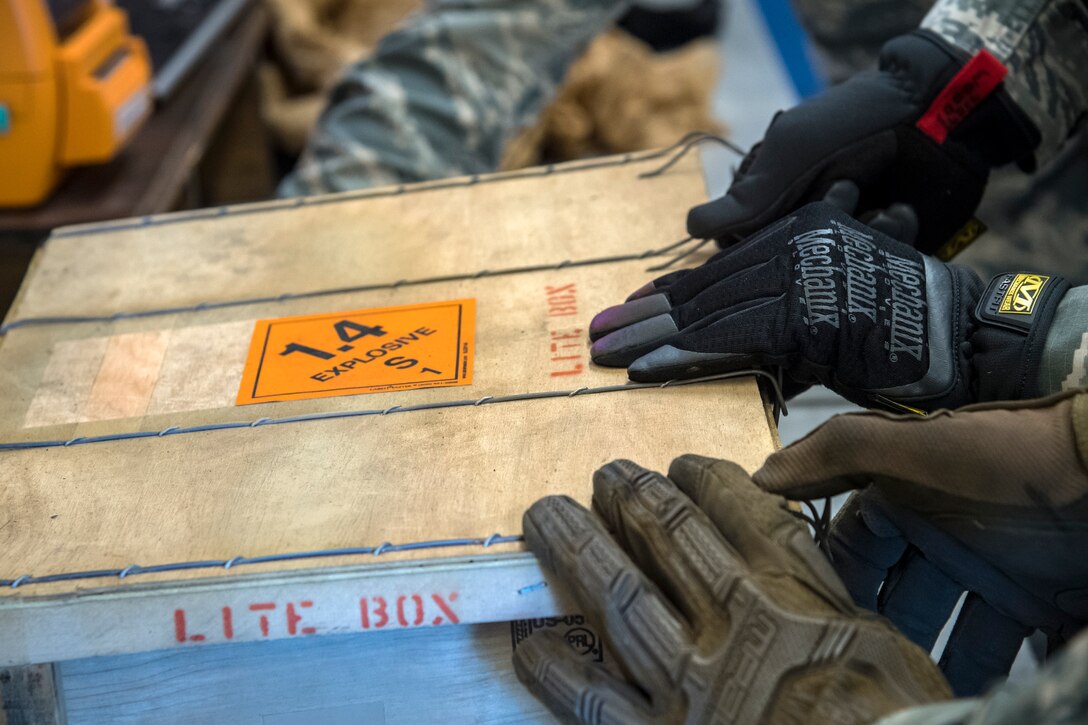 Airmen from the 23d Maintenance Squadron (MXS), lock a crate containing munitions following an inspection, July 10, 2018, at Moody Air Force Base, Ga. Munitions inspectors enhance Moody’s combat capabilities by inspecting and approving safe and serviceable ammo. (U.S. Air Force photo by Airman 1st Class Eugene Oliver)