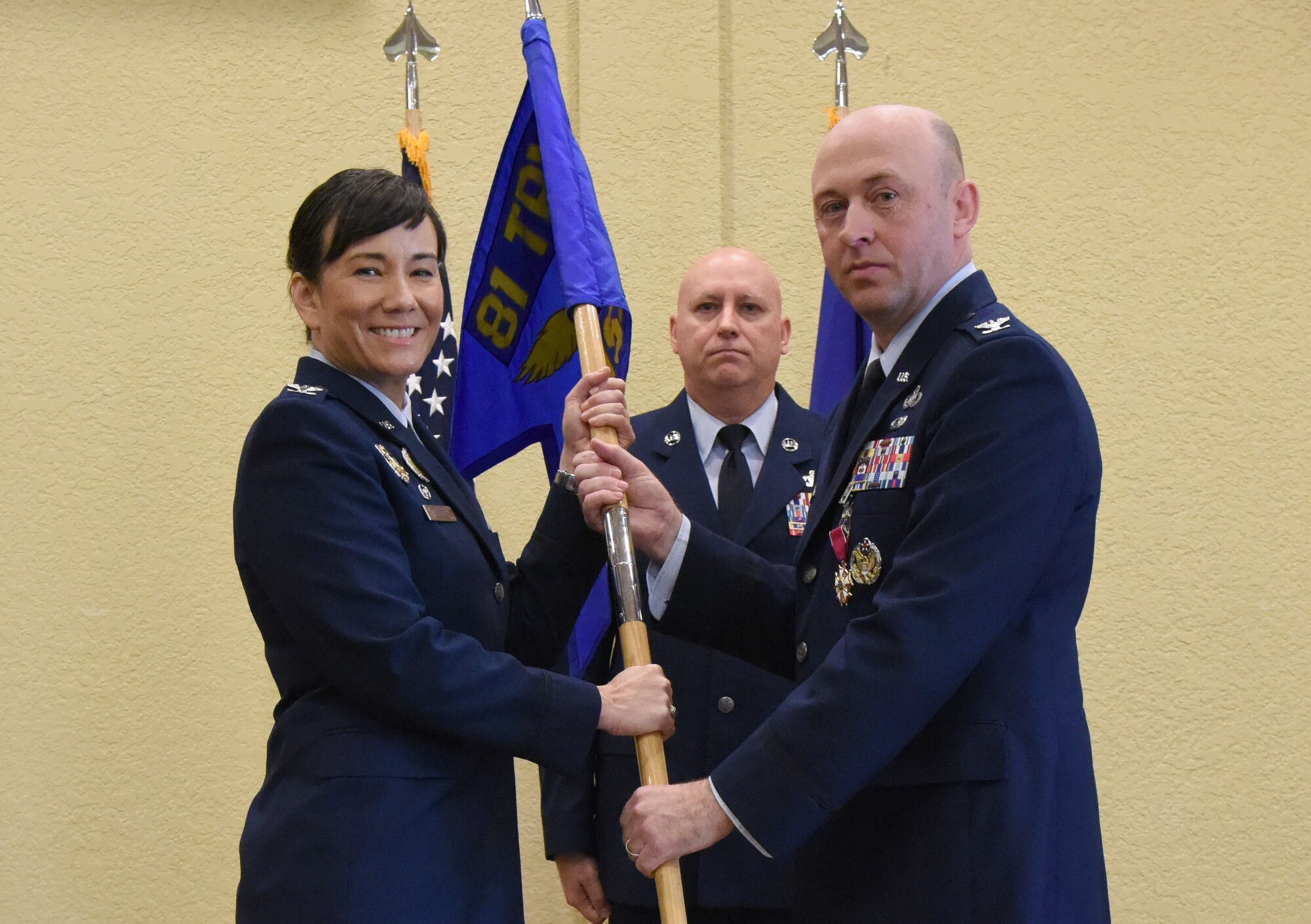 U.S. Air Force Col. Debra Lovette, 81st Training Wing commander, takes the 81st Mission Support Group guidon from Col. Danny Davis, outgoing 81st MSG commander, during the 81st MSG change of command ceremony in the Bay Breeze Event Center at Keesler Air Force Base, Mississippi, July 19, 2018. The passing of the guidon is a ceremonial symbol of exchanging command from one commander to another. (U.S. Air Force photo by Kemberly Groue)