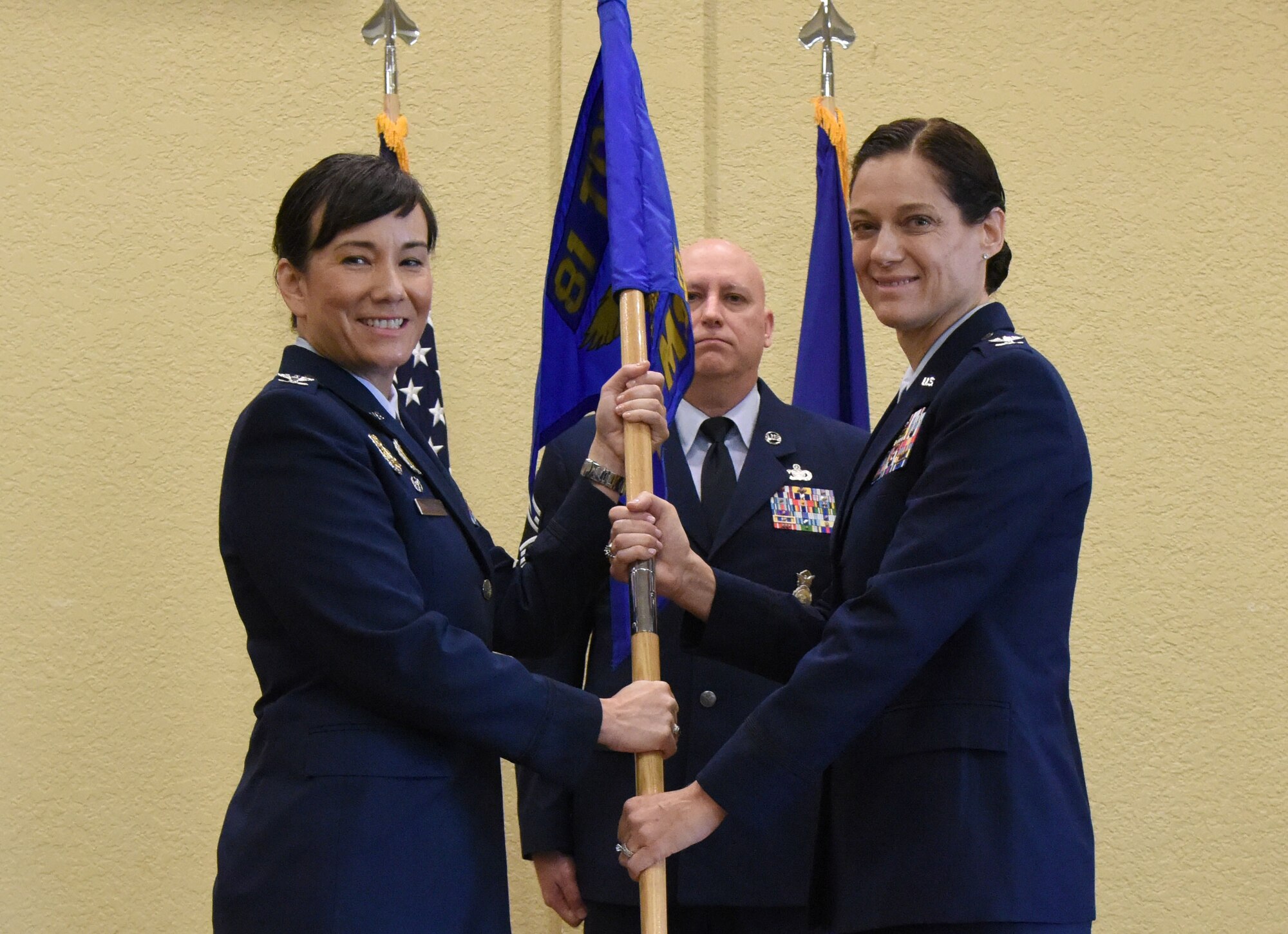 U.S. Air Force Col. Debra Lovette, 81st Training Wing commander, passes the 81st Mission Support Group guidon to Col. Marcia Quigley, 81st MSG commander, during the 81st MSG change of command ceremony in the Bay Breeze Event Center at Keesler Air Force Base, Mississippi, July 19, 2018. The passing of the guidon is a ceremonial symbol of exchanging command from one commander to another. (U.S. Air Force photo by Kemberly Groue)