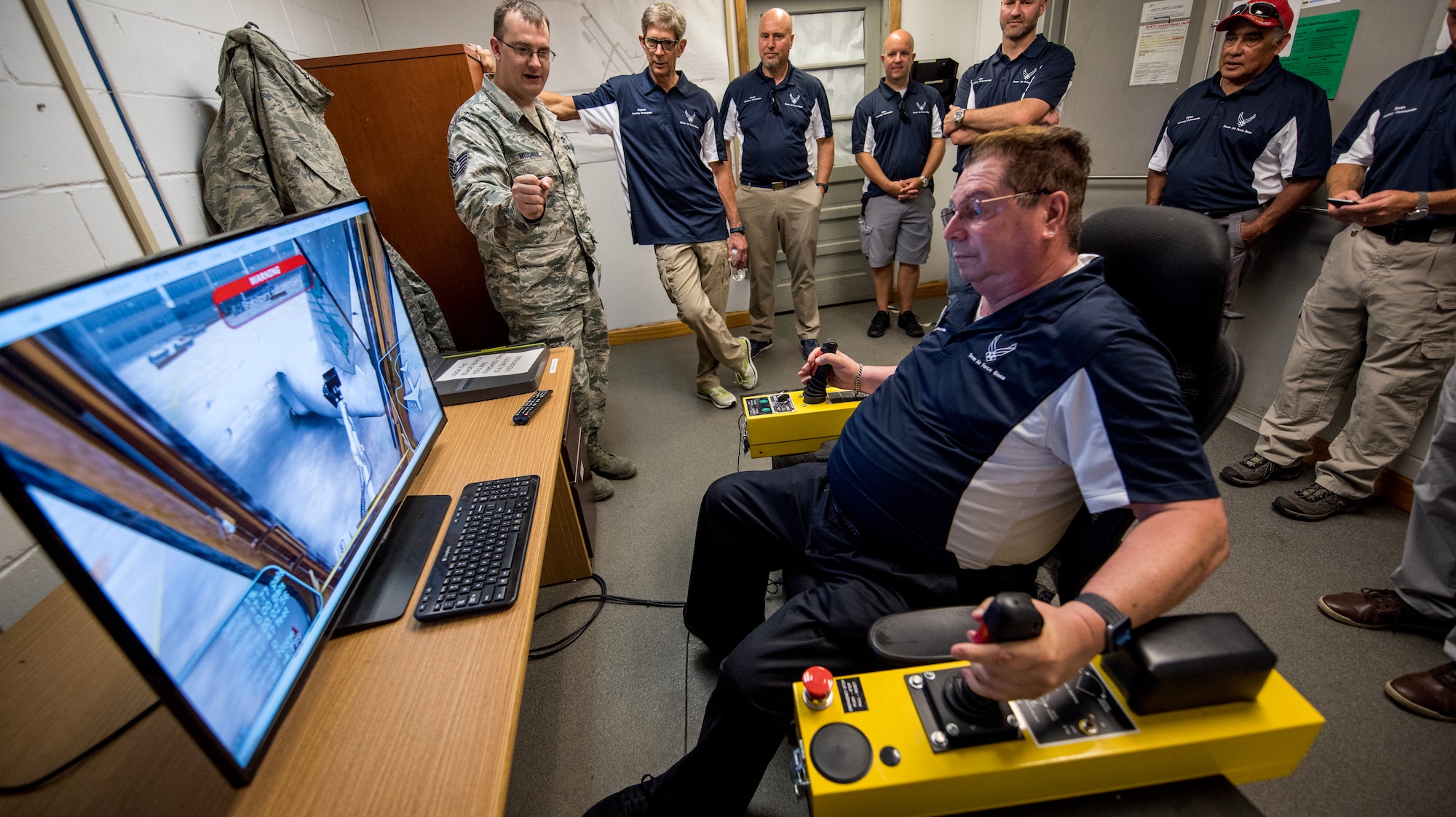 Ron Barisano, 512th Force Support Squadron honorary commander, receives hands-on experience with a de-icer simulator at Dover Air Force Base, Del., July 19, 2018. The de-icer simulator trains and familiarizes Airmen with de-icing vehicle controls and procedures before servicing real-world aircraft. (U.S. Air Force photo by Damien Taylor)