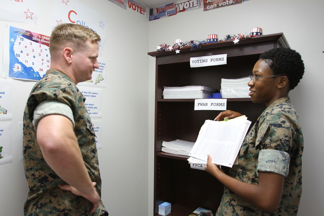 U.S. Marine Corps SSgt. Chris Light (left) spoke to LCpl. Mykkeria Johnson (right) by the Marine Corps Logistics Base Albany Adjutant Office to learn how to vote ahead of the general election in Georgia. The Adjutant Office held the 2nd annual Voting Convention for Marines and civilian-Marines, July 19. The event is part of an annual training for all active duty personnel. (U. S. Marine Corps photo by Re-Essa Buckels)