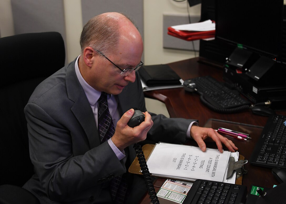 Dominic Pohl, 25th Air Force executive director, makes a test call using a script over the High Frequency Global Communication System radio July 19, 2018, on Grand Forks Air Force Base, North Dakota. Before broadcasting his voice across the world, Pohl received a mission brief for the 319th Communication Squadron HFGCS unit highlighting the unique capabilities it provides from Grand Forks AFB. (U.S. Air Force photo by Airman 1st Class Elora J. Martinez)