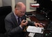 Dominic Pohl, 25th Air Force executive director, makes a test call using a script over the High Frequency Global Communication System radio July 19, 2018, on Grand Forks Air Force Base, North Dakota. Before broadcasting his voice across the world, Pohl received a mission brief for the 319th Communication Squadron HFGCS unit highlighting the unique capabilities it provides from Grand Forks AFB. (U.S. Air Force photo by Airman 1st Class Elora J. Martinez)