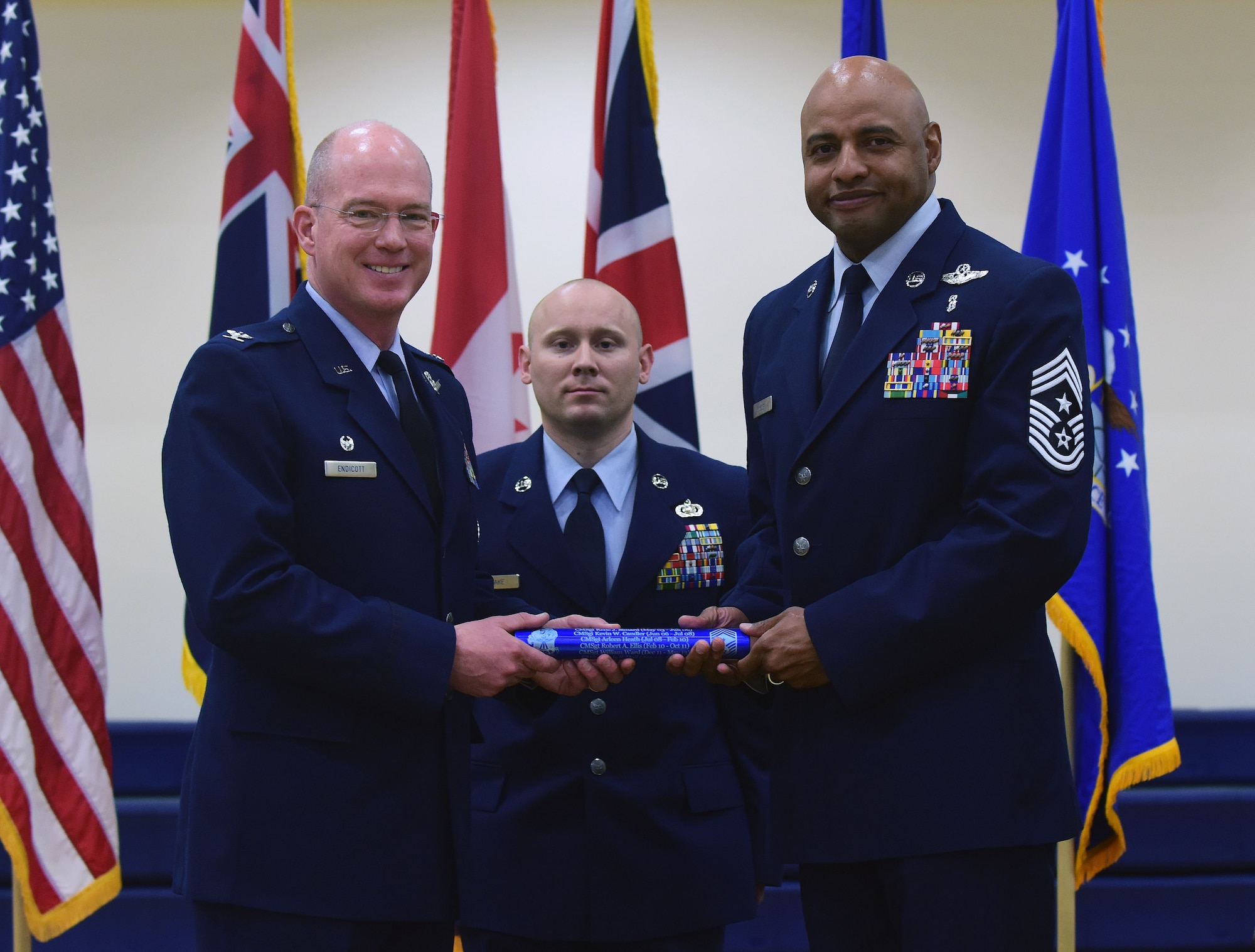 Chief Master Sgt. Rod Lindsey, right, 460th Space Wing outgoing command chief, relinquishes the baton symbolizing the change of leadership to Col. Troy L. Endicott, 460th SW commander, on Buckley Air Force Base, Colorado, July 20, 2018.