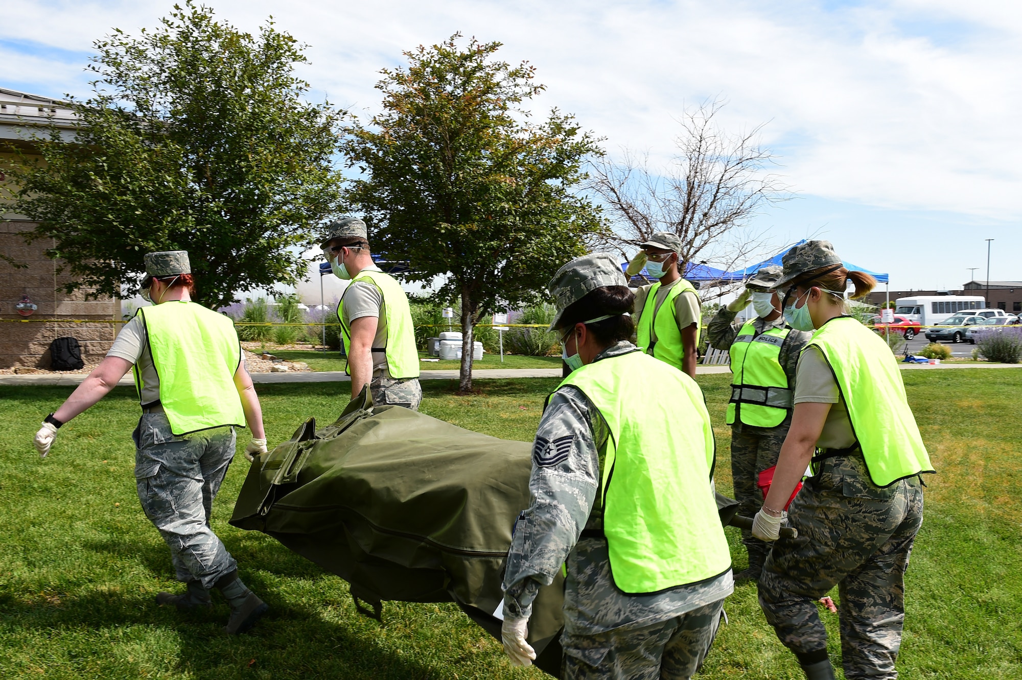 Airmen from the 460th Force Support Squadron carry a simulated corpse out of a cordoned area as part of search and recovery training on July 19, 2018, on Buckley Air Force Base, Colorado. The training ensures Airmen are prepared for crisis response situations. (U.S. Air Force photo by Senior Airman AJ Duprey)