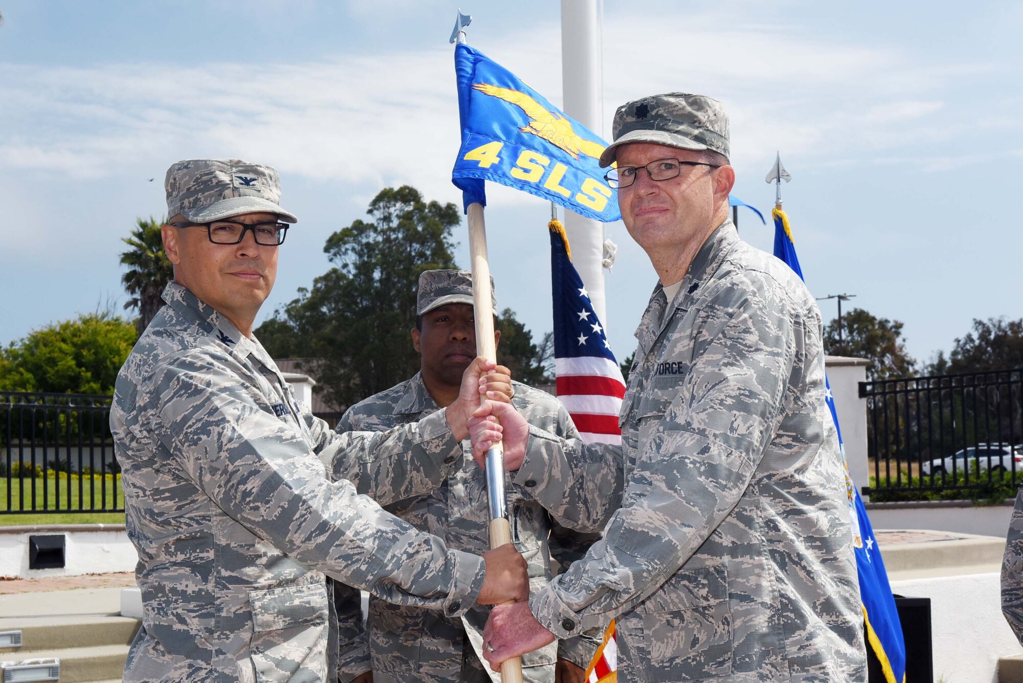 Col. Curtis Hernandez, 30th Operations Group commander, hands the guide on to Lt. Col. Kenneth Decker, 4th Space Launch Squadron commander, during the 30th Launch Group deactivation ceremony on July 20, 2018, at Vandenberg Air Force Base, Calif. The 30th Space Wing inactivated the 30th LCG, merging their range responsibilities and personnel with the 30th OG. (U.S. Air Force photo by Tech. Sgt. Jim Araos/Released)