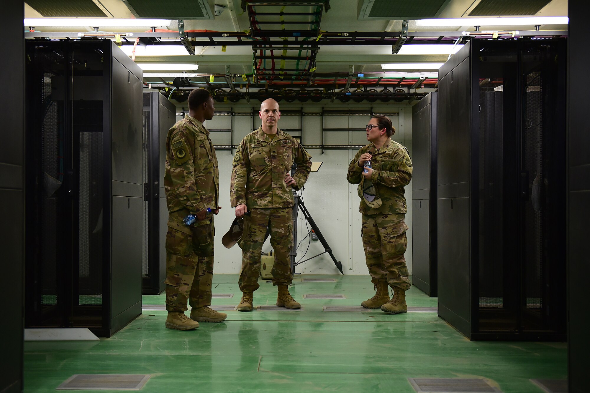 Three Airman stand in a brand new building